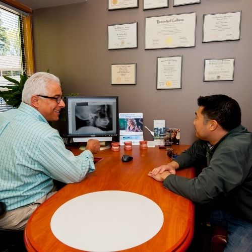 Dr. Jeff Schur and a male patient looking at an x-ray during consultation