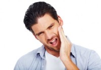 A man holding his face with jaw pain before TMJ treatment in Bellevue